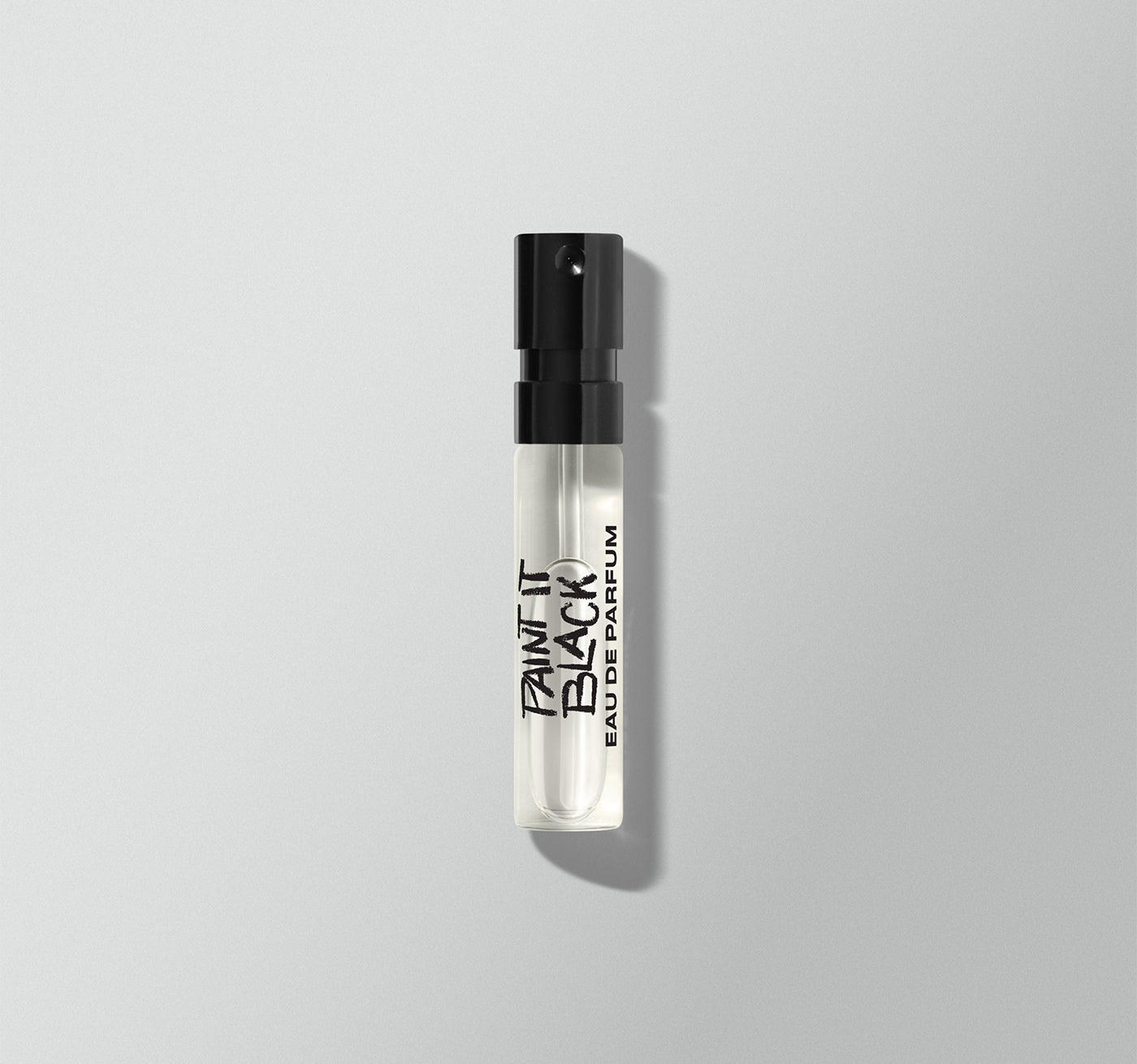 Perfume bottle labeled 'Paint It Black' on a gray background