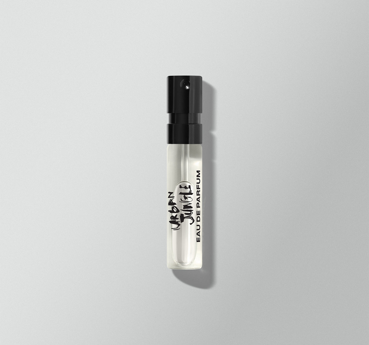 Small perfume bottle labeled 'Urban Jungle' by the Rolling Stones on a light gray background